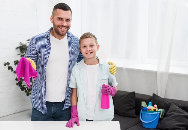 Padre e figlio che posano mentre pulendo la casa