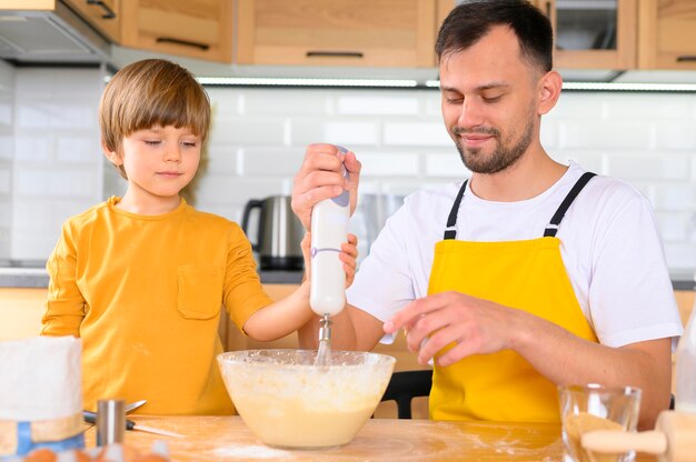 Padre e figlio che producono pasta con il miscelatore