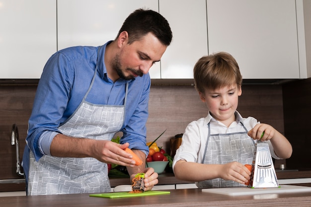 Padre e figlio di angolo basso che cucinano a casa