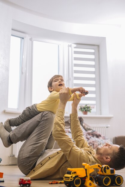 Padre e figlio divertirsi in salotto