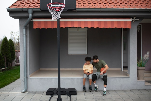 Padre e figlio giocano insieme a basket in giardino