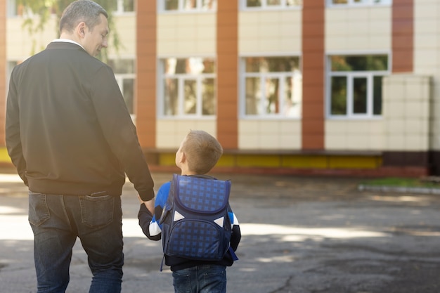 Padre e figlio il primo giorno di scuola vista posteriore