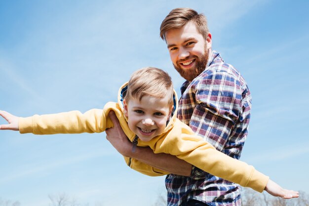 Padre e figlio piccolo che giocano insieme in un parco