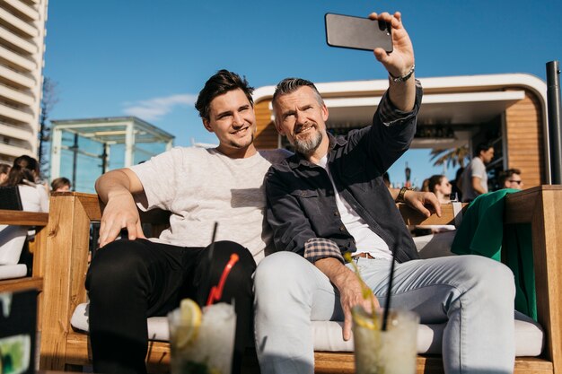 Padre e figlio prendendo selfie nel bar