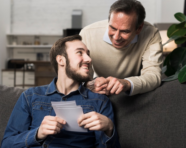 Padre e figlio si divertono e guardano le foto