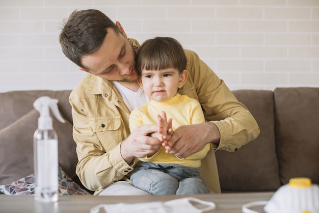 Padre e figlio sul divano e maschere mediche sul tavolo