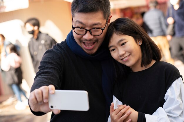 Padre e ragazza a tiro medio che si fanno selfie