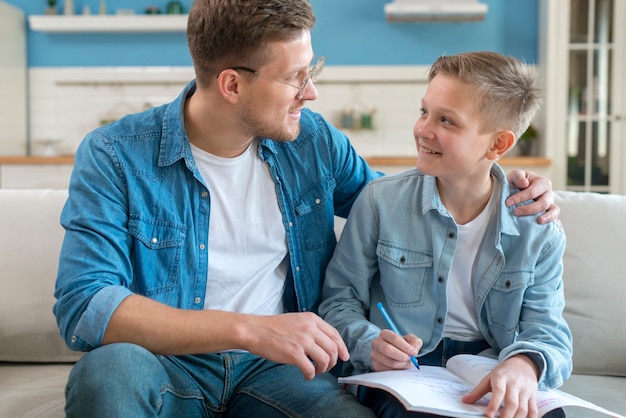 Padre felice che aiuta suo figlio a fare i compiti