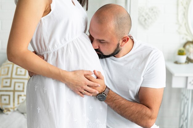 Padre felice che bacia la pancia di sua moglie