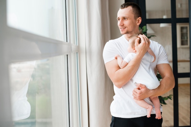 Padre in piedi e tenendo il bambino