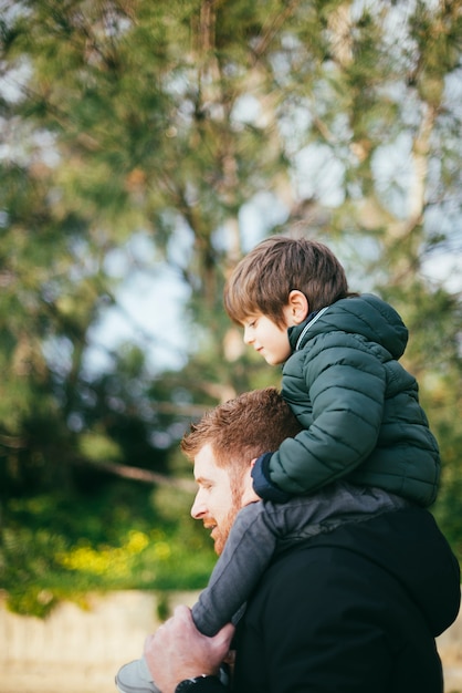 Padre portando il figlio sulle spalle