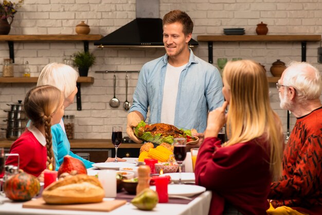 Padre portando il tacchino con condimento per insalata vista lunga