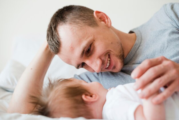 Padre sdraiato con il bambino a letto