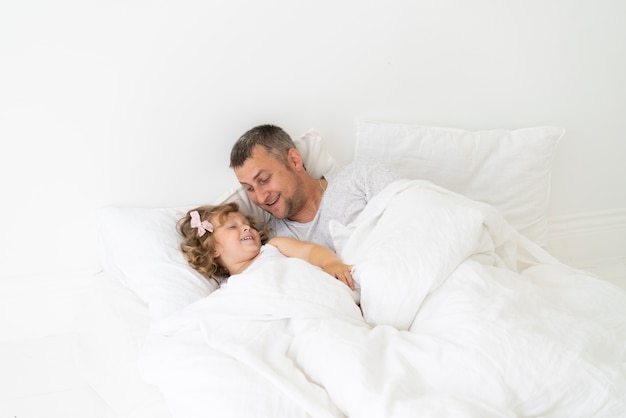 Padre seduto con la figlia in camera da letto