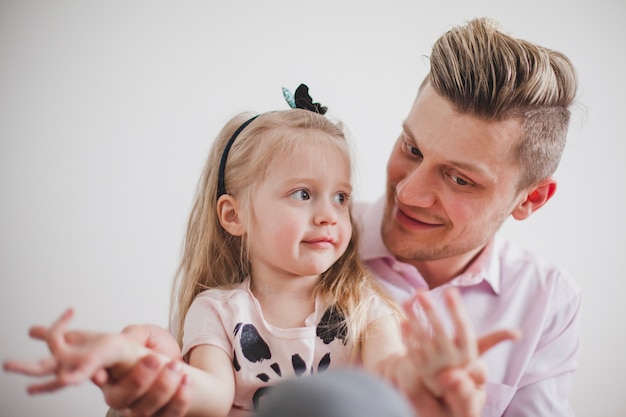 Padre sorridente giocare con le mani della figlia