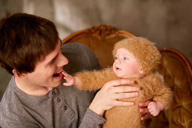 Padre tiene suo figlio e si siede sulla sedia