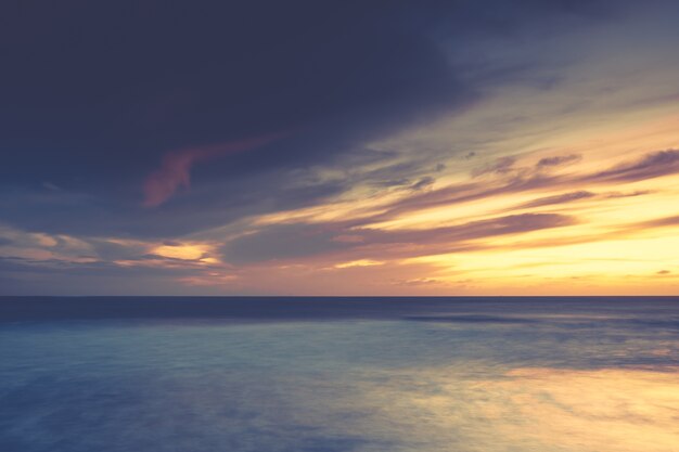 Paesaggi mozzafiato del tramonto sull'oceano calmo, perfetto per uno sfondo