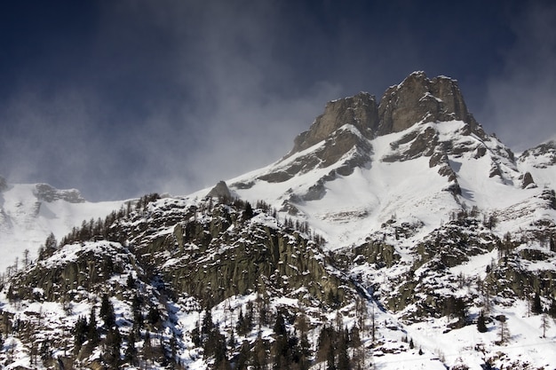 Paesaggi mozzafiato delle montagne innevate sotto un suggestivo cielo nuvoloso