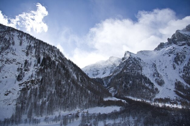 Paesaggi mozzafiato delle montagne innevate sotto un suggestivo cielo nuvoloso