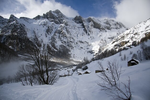 Paesaggi mozzafiato delle montagne innevate sotto un suggestivo cielo nuvoloso