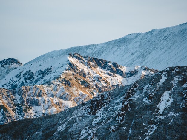 Paesaggi mozzafiato di alte montagne rocciose Tatra coperte di neve in Polonia