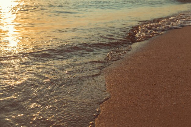 Paesaggio con tramonto sul mare sulla spiaggia