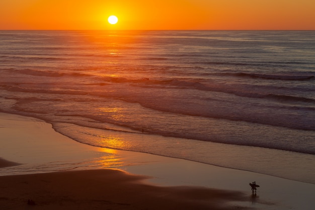 Paesaggio di bello tramonto che riflette sul mare dalla spiaggia nel Portogallo, Algarve