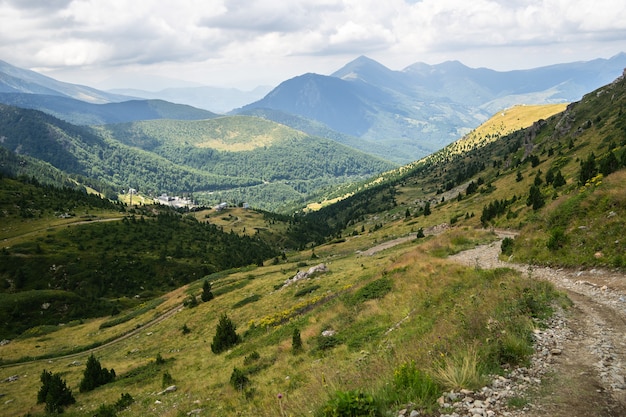 Paesaggio di colline ricoperte di vegetazione con montagne rocciose
