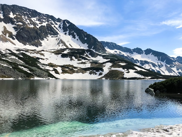 Paesaggio di montagna che si riflette nell'acqua, pittoresca natura invernale del Parco Nazionale dei Tatra