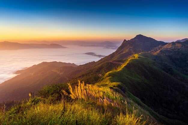 Paesaggio di nebbia mattutina e montagne all'alba.