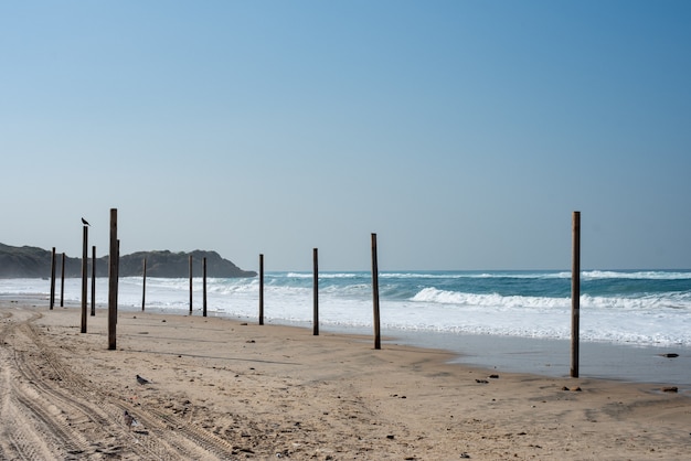 Paesaggio di un mare con colonne di legno su di esso circondato dal mare