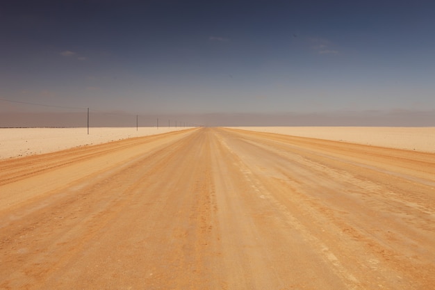 Paesaggio di una strada in un deserto sotto la luce del sole alla luce del giorno