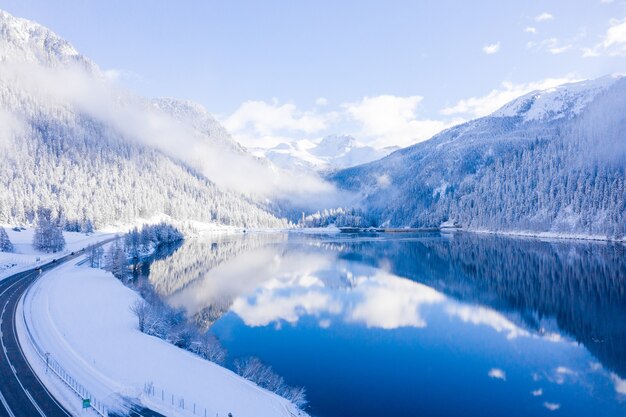 Paesaggio invernale con montagna nebbiosa nebbiosa e lago panoramico di montagna di cristallo