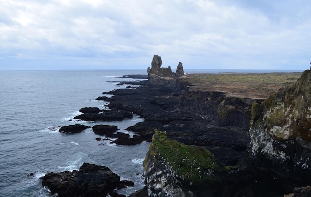 Paesaggio marino panoramico con scogliere di roccia lavica e formazioni rocciose