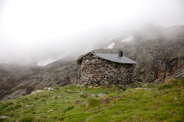 Paesaggio nebbioso e una piccola casa