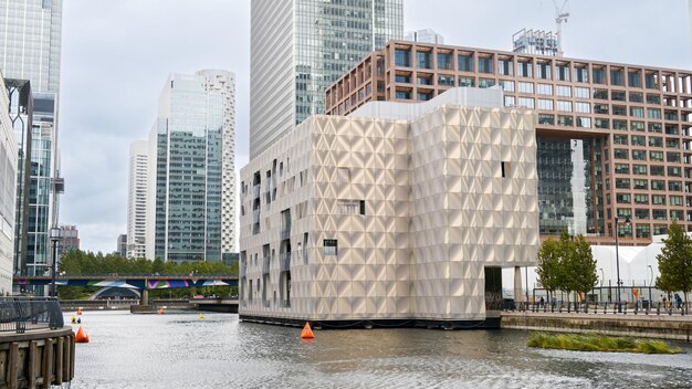 Paesaggio stradale dei canali d'acqua del quartiere di Canary Wharf con edifici moderni e grattacieli