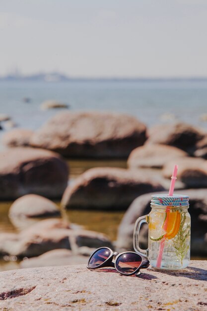 Paesaggio sulla spiaggia con occhiali da sole e bevande rinfrescanti