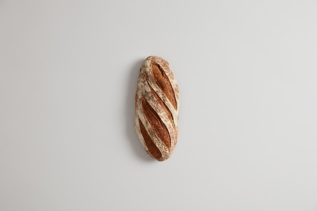 Pagnotta di pane bianco lungo a base di lievito e farina biologica, isolata. Concetto di cottura in casa. Alimentazione sana. Prodotto a base di carboidrati. Mangiare e consumismo. Vista dall'alto. Messa a fuoco selettiva.