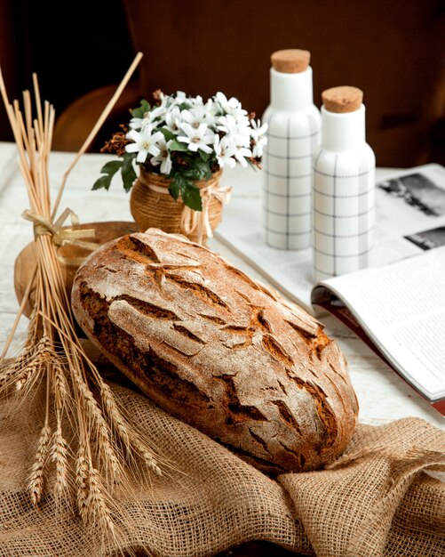 Pagnotta di pane con ramo di grano e fiori