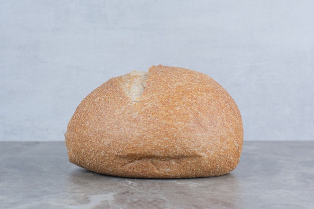 Pagnotta di pane fresco su sfondo marmo.