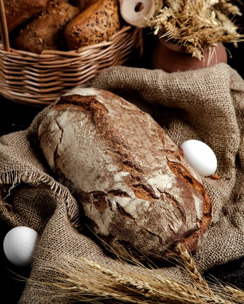 Pagnotta di pane nero servita su tela di lino in stile rustico