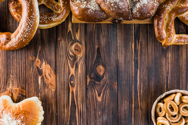 Pagnotta e ciambelline salate intrecciate di recente al forno sulla tavola di legno con lo spazio della copia