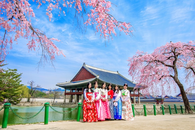 Palazzo Gyeongbokgung con fiori di ciliegio in primavera e turisti con abiti Hanbok