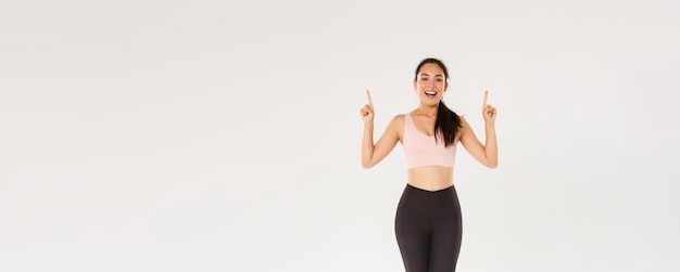 Palestra sportiva e concetto di corpo sano per tutta la lunghezza dell'atleta femminile asiatica sorridente allegra di forma fisica
