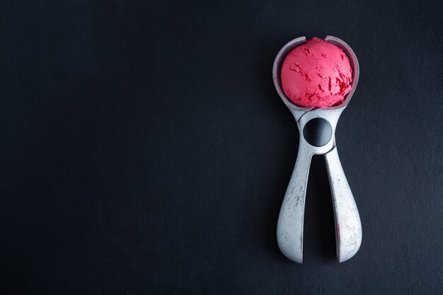 Paletta fruttata del gelato alla fragola sul cucchiaio del gelato. Vista dall'alto.