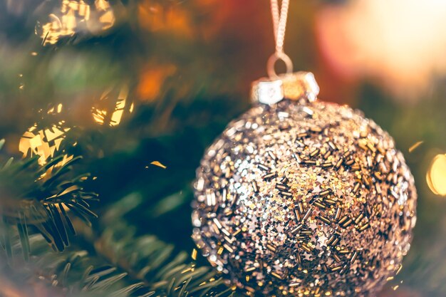 Palla di Natale lucida d'argento su un primo piano del ramo di un albero di Natale