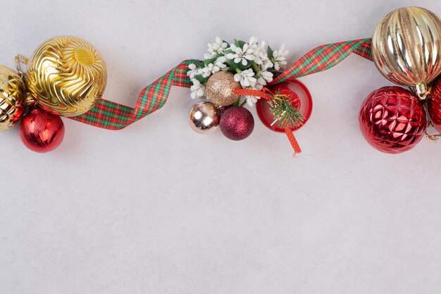 Palle della decorazione di Natale con la fascia sulla tavola bianca.