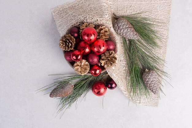 Palle di Natale e pigna sul tavolo bianco.