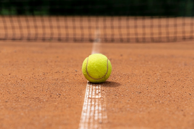 Pallina da tennis di vista frontale sulla terra del campo