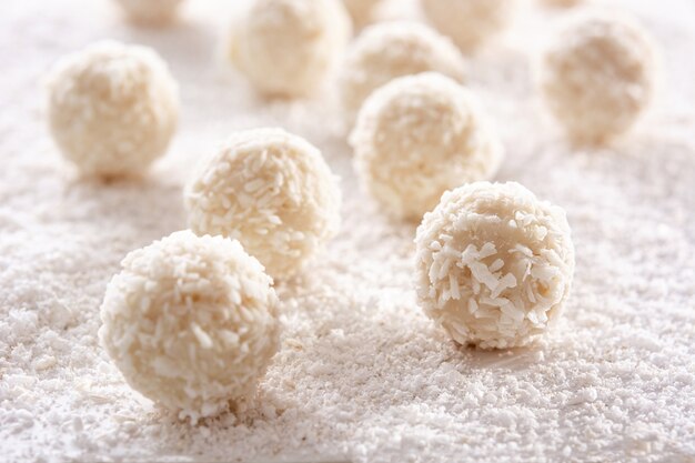 Palline di cocco fatte in casa su un tavolo di legno bianco